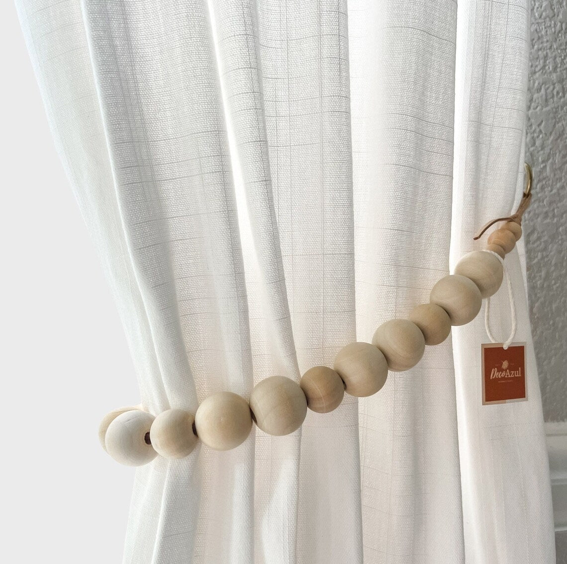 curtain holdback on a window with white curtains